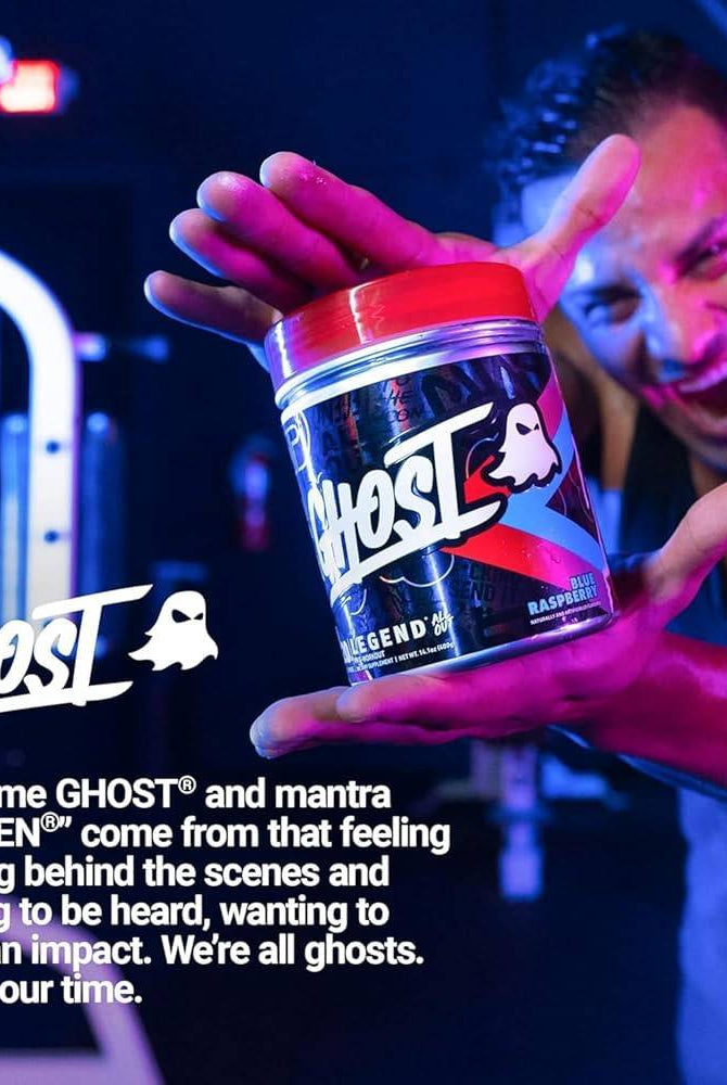 Man holding Ghost Legend All Out Pre Workout Blue Raspberry tub in gym setting. Promotes energy, performance, and motivation with 400mg caffeine.