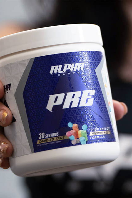 Close-up of Alpha Supps Candied Tart Pre-Workout held by user, emphasizing product design and fitness supplement branding.