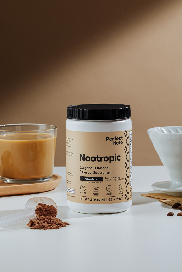 Perfect Keto Nootropic Chocolate supplement placed with coffee, chocolate, and a scoop of powder, promoting brain boost and mental clarity.