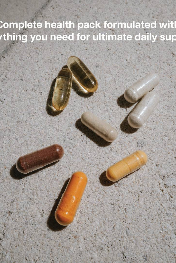 Assorted capsules from the Revive Vitamin Pack on a stone surface, formulated for complete daily health and immune support.