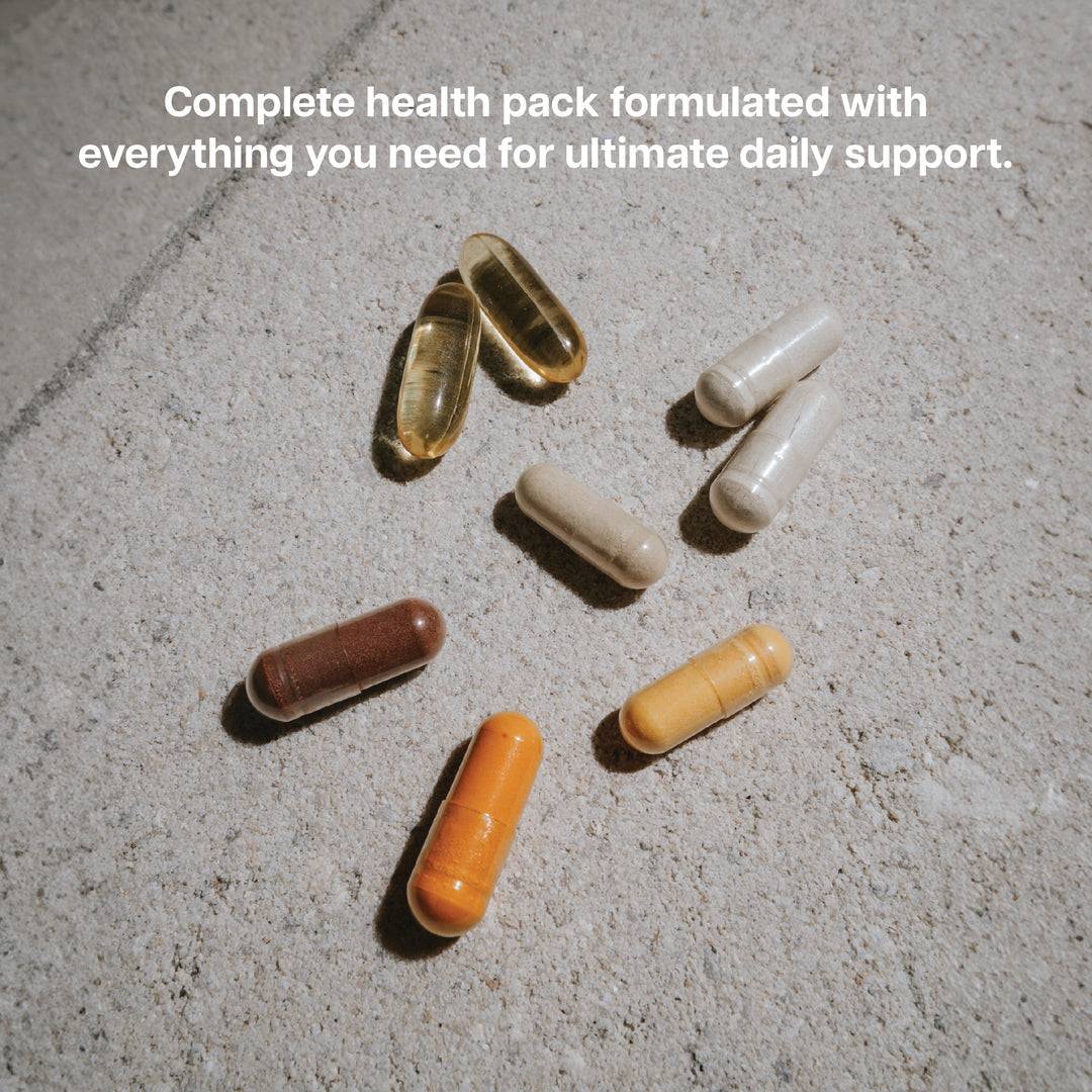 Assorted capsules from the Revive Vitamin Pack on a stone surface, formulated for complete daily health and immune support.
