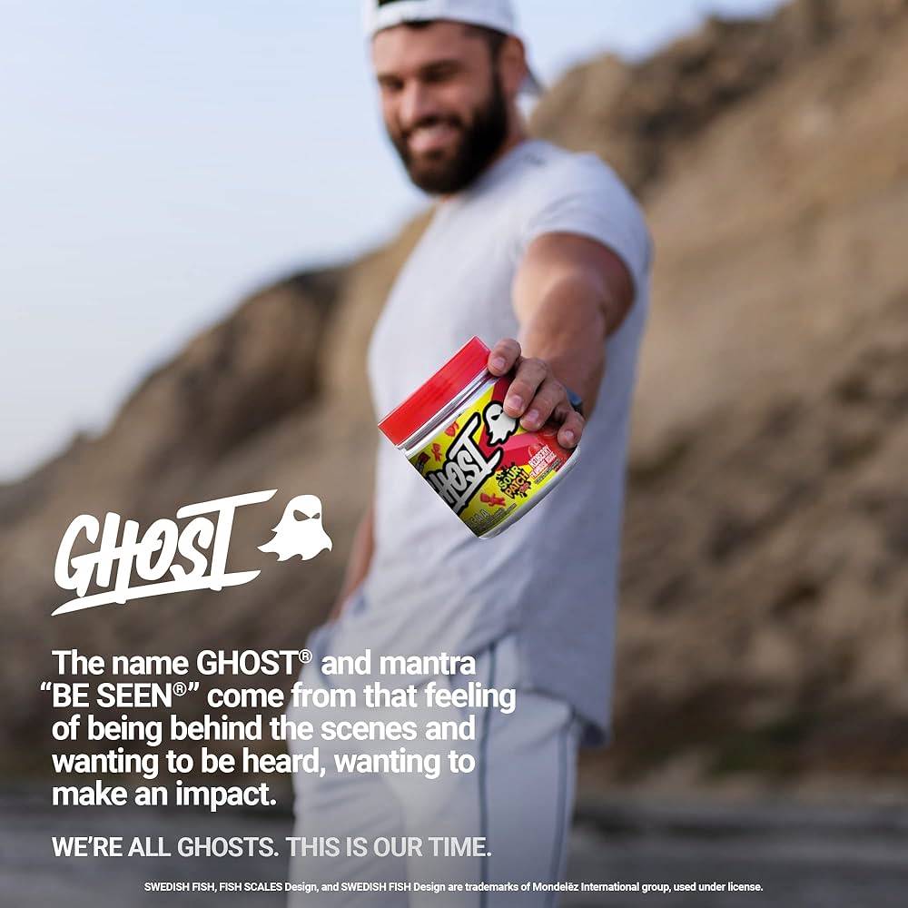 Man holding GHOST BCAAs Sour Patch Kids Watermelon tub outdoors, promoting the brand's fitness supplement lifestyle message.