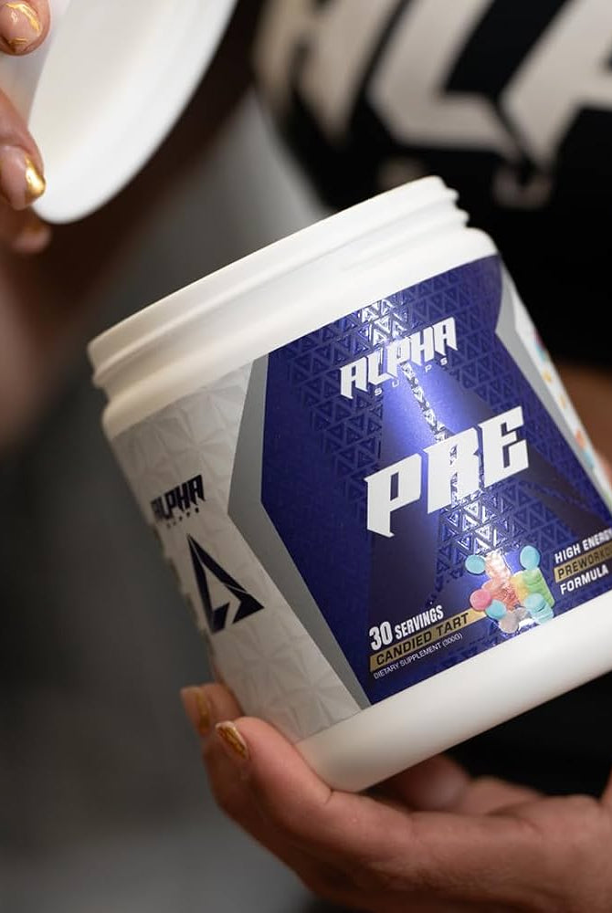 Person holding Alpha Supps Candied Tart Pre-Workout, showcasing product label and branding for energy and focus support.