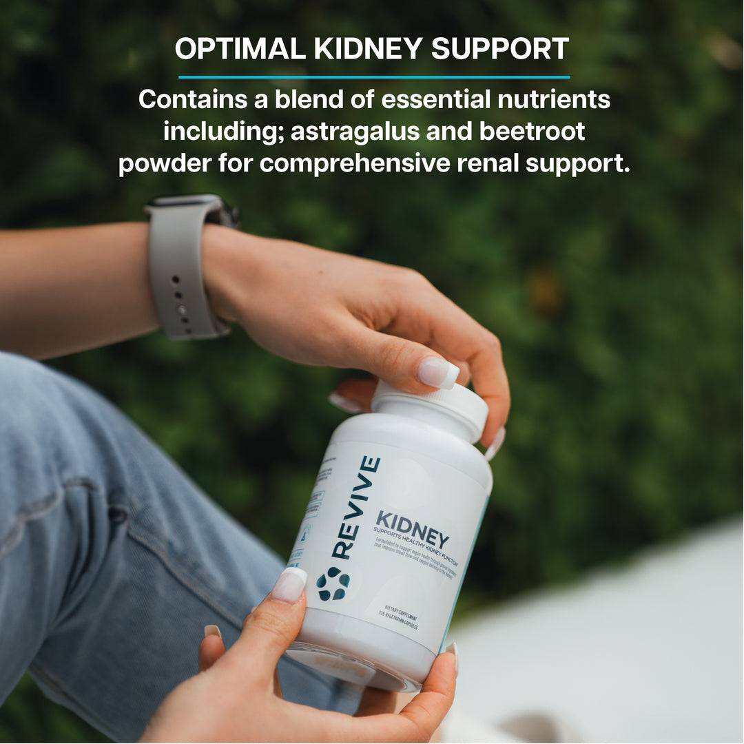 Person holding Revive Kidney Supplement bottle outdoors. Contains astragalus and beetroot for comprehensive kidney and renal health support.