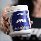 Close-up of Alpha Supps Candied Tart Pre-Workout held by user, emphasizing product design and fitness supplement branding.